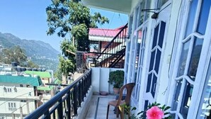 A balcony with a view of a mountain, a chair, and potted plants. - Marvelous 2-bedroom house in Solan perfect for a relaxing getaway (Solan)