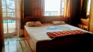 A bedroom with a bed, a window, and a view of the outside. - Marvelous 2-bedroom house in Solan perfect for a relaxing getaway (Solan)