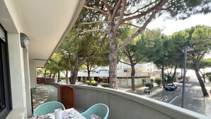 Ein Balkon mit einem Tisch für zwei Personen, Stühlen und Blick auf die Straße sowie die umliegenden Gebäude.