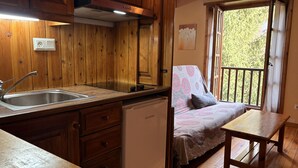 Eine Holz-Küche mit Spüle, Geschirrspüler und Blick auf Grünflächen.