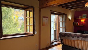 Ein Zimmer mit Bett, Fenster, Tür und einem Regal mit Büchern.