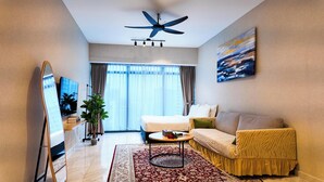 Una habitación de hotel moderna con cama, sofá, mesa de centro y ventilador de techo.