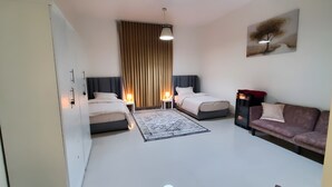 Ein Hotelzimmer mit Bett, Sofa, Schreibtisch und Lampe.