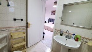Ein Badezimmer mit Waschbecken, Spiegel und Ablageflächen.