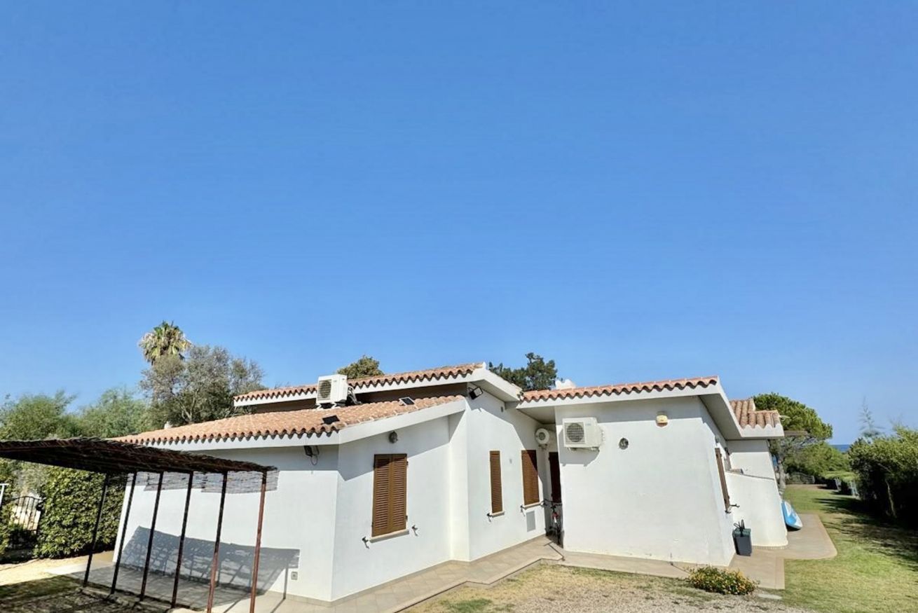 A single-story building with a tiled roof, a covered patio area, and a small garden.