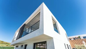Ein modernes Gebäude mit einem dreieckigen Dach, großen Fenstern und einer flachen Fassade.