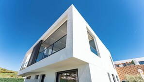 Ein modernes Gebäude mit einem dreieckigen Dach, großen Fenstern und einer flachen Fassade.