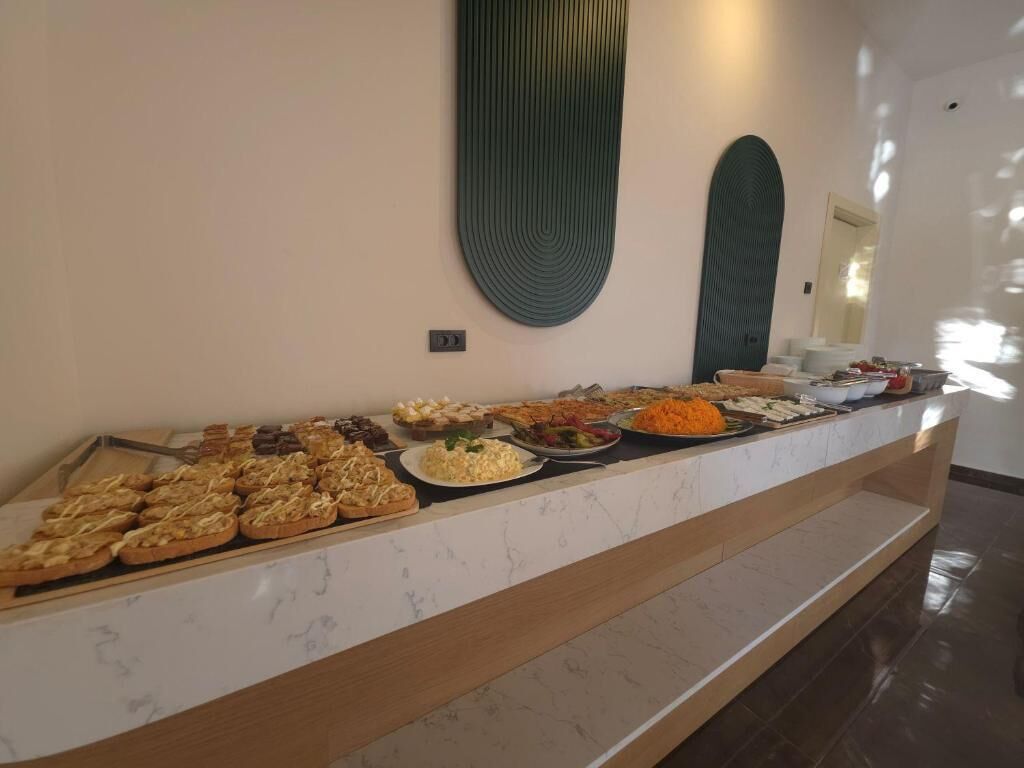 Un buffet proposant une variété de plats, un plan de travail en marbre et un élément décoratif fixé au mur.