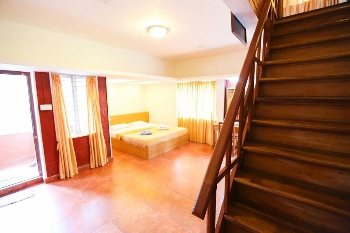 Ein Zimmer mit einem Bett, einer Treppe und einer Tür, die nach draußen führt.