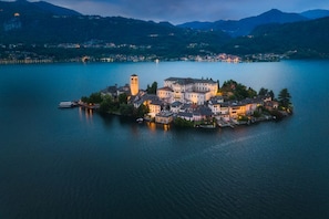 A lakeside town with a prominent tower, a large building, and a boat dock.