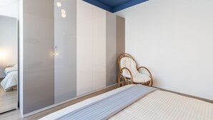 A bedroom with a bed, a wardrobe, a chair, and a mirror. - Casa Giada - Downtown Arona - 500 m from the lake - WiFi - By Guestaly (Arona)