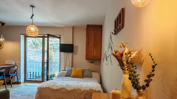 Ein Schlafzimmer mit Bett, Nachttisch und Schreibtisch mit Stühlen.