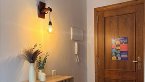Ein Holzkabinent mit einer Lampe, einem an der Wand befestigten Telefon und einer Tür mit einem farbenfrohen Plakat.