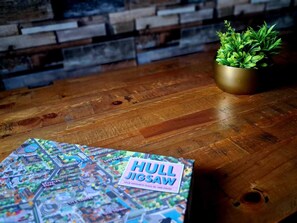 Une table en bois sur laquelle se trouve un puzzle intitulé « HULL JIGSAW » et une petite plante en pot.