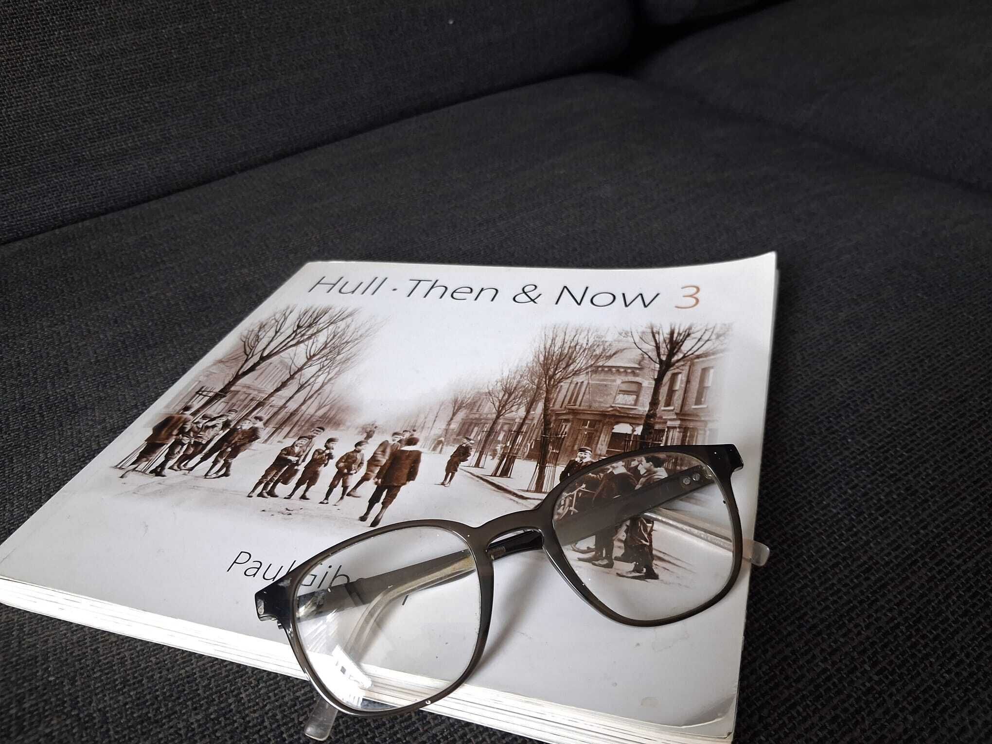 Ein Buch mit dem Titel 'Hull-Then & Now 3', das ein Foto einer historischen Szene zeigt, auf einer dunklen Stoffoberfläche platziert.