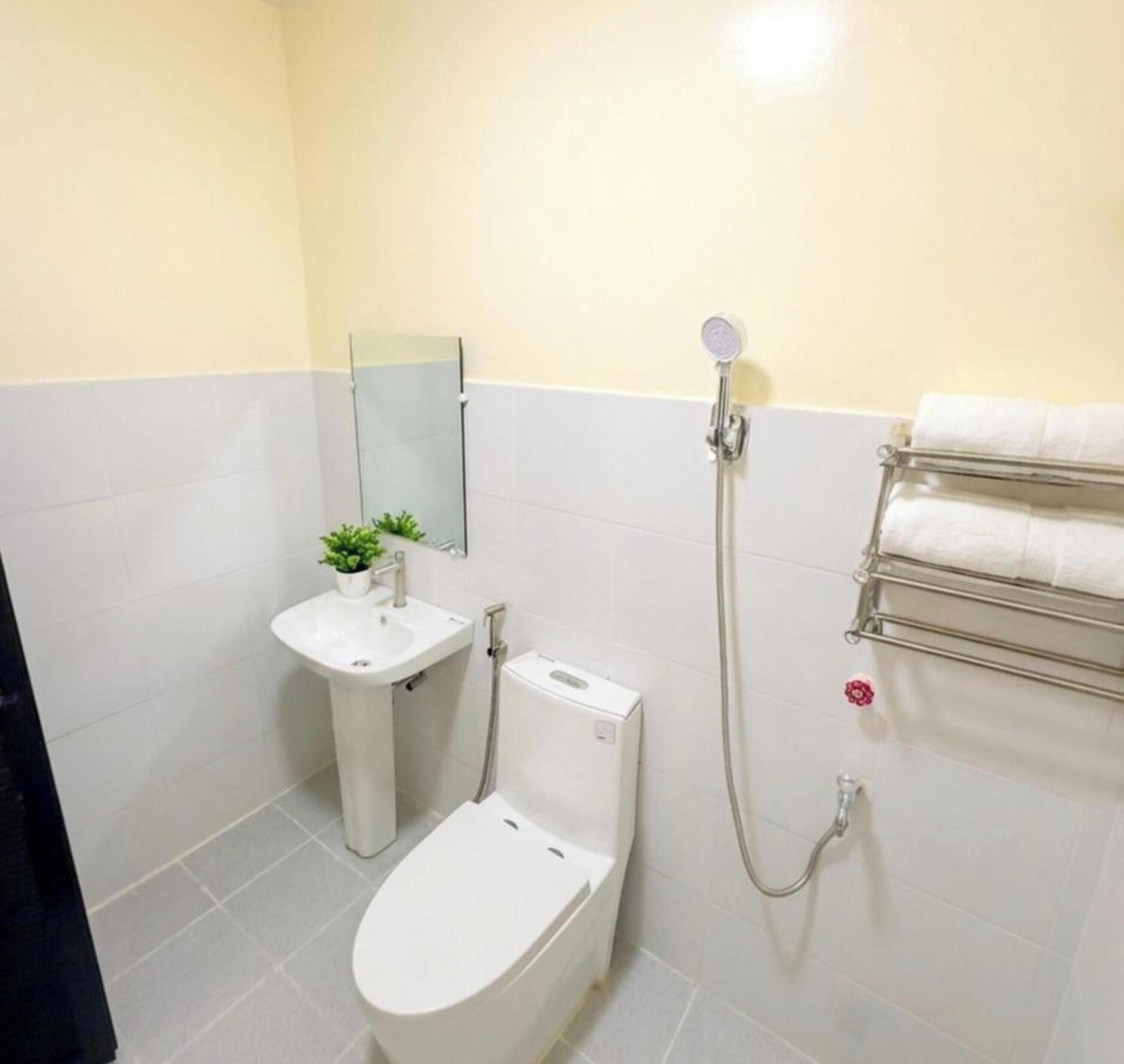 A compact bathroom with a toilet, sink, and shower.