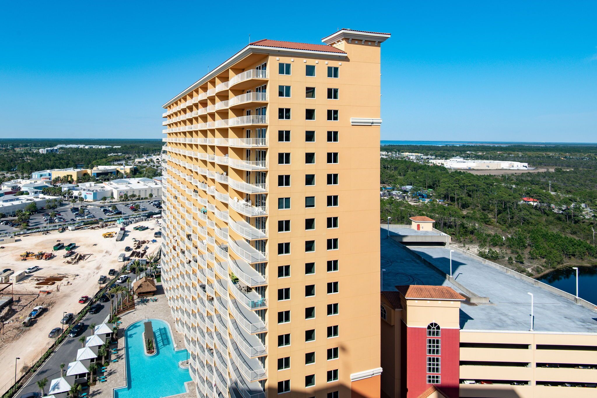 Un hôtel de grande hauteur doté de nombreux balcons, d’une piscine et offrant une vue sur les environs.