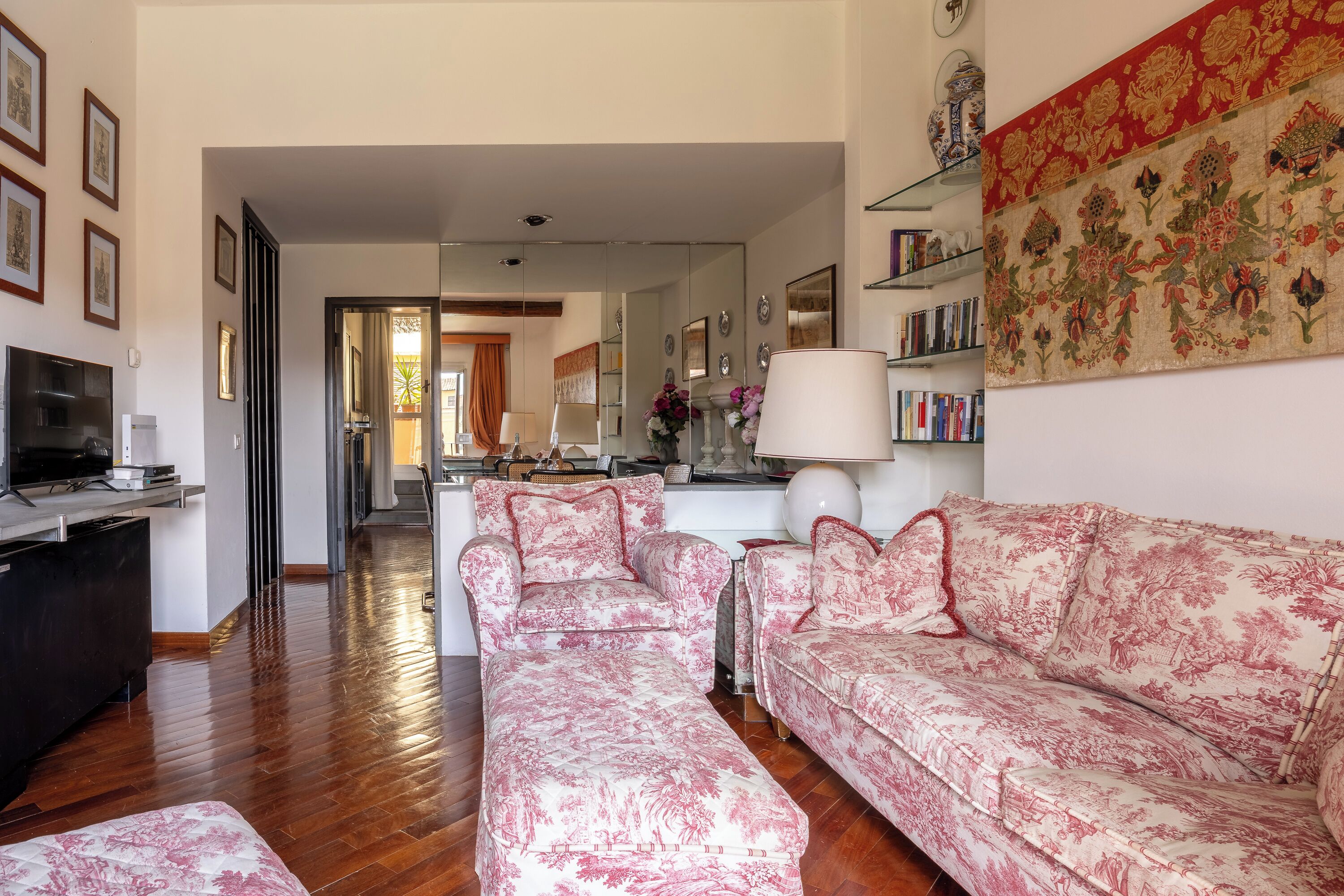 A living room with a sofa, a TV, and a bookshelf.