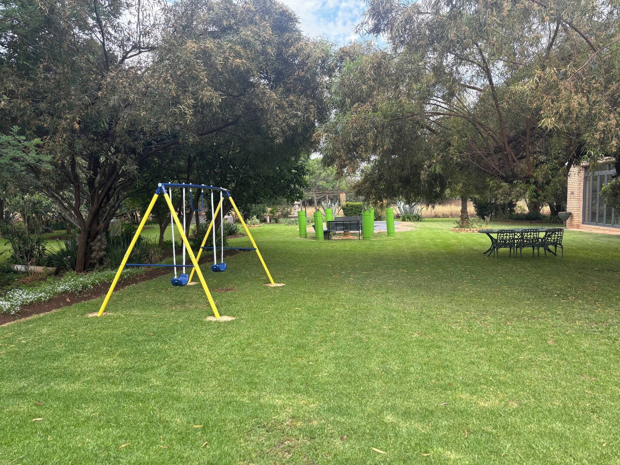 Un parque con un columpio, una mesa de picnic y un banco.