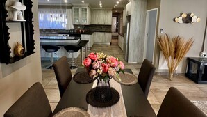 A dining area with a long table, chairs, and a vase of flowers. - Antelope Farm Events (Akasia)
