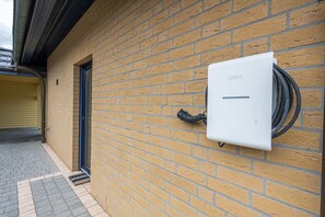 A brick wall with a white electrical box labeled 'SENEC' and a black cable connected to it. - Villa by the Lake for 4 People (120 m²) in Untergöhren (Göhren-Lebbin)