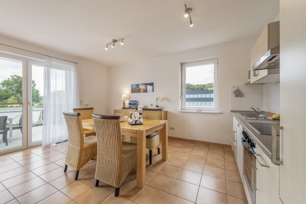 Una cocina moderna con comedor, ventanas amplias y vistas al exterior.