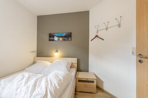 Ein Schlafzimmer mit einem Bett, einem Nachttisch und einer Wandleuchte.