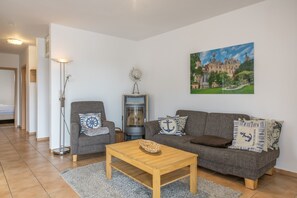 Ein Wohnzimmer mit einer Couch, einem Sessel und einem Holztisch.