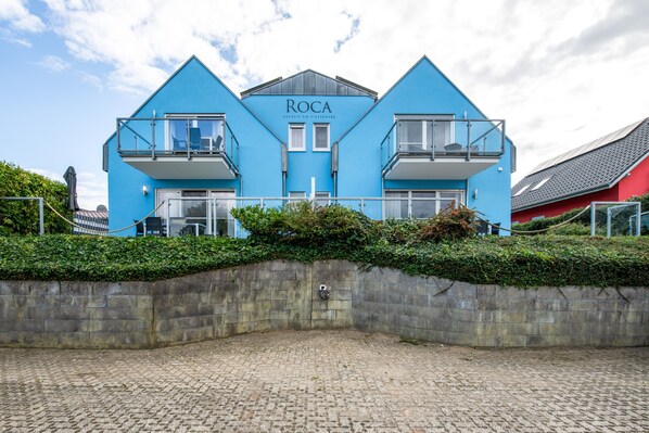 Ein zweigeschossiges Gebäude mit einer blauen Fassade und dem Schriftzug 'ROCA' im oberen Bereich.