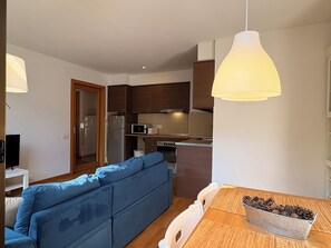 A compact living space with a kitchenette, a sofa, and a dining table with pine cones. - Charming, good location and parking - Aüt 2 (Pla de l'Ermita)