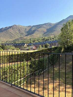 Un paisaje montañoso con una hilera de edificios al fondo.