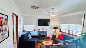 A living room with a fireplace, a television, and two sofas.