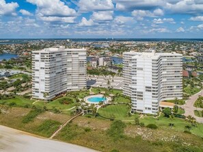 Two high-rise buildings with a pool and landscaped areas in between. - Beachfront 2BR/2BA condo with pool, WiFi, kitchen, and Marco Island views. (Marco Island)