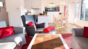 Ein modernes Wohnzimmer mit grauen Sofas, einem roten Teppich und einem gefliesten Couchtisch.