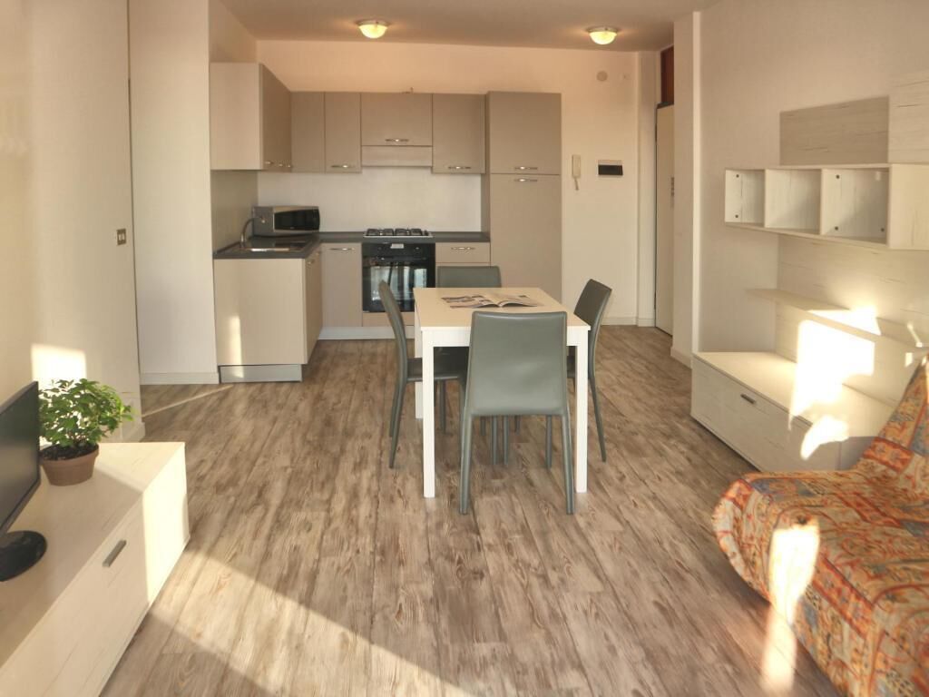A compact living space with a kitchenette, a dining area, and a sofa.