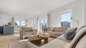 En moderne stue med sofa, sofabord og udsigt ud