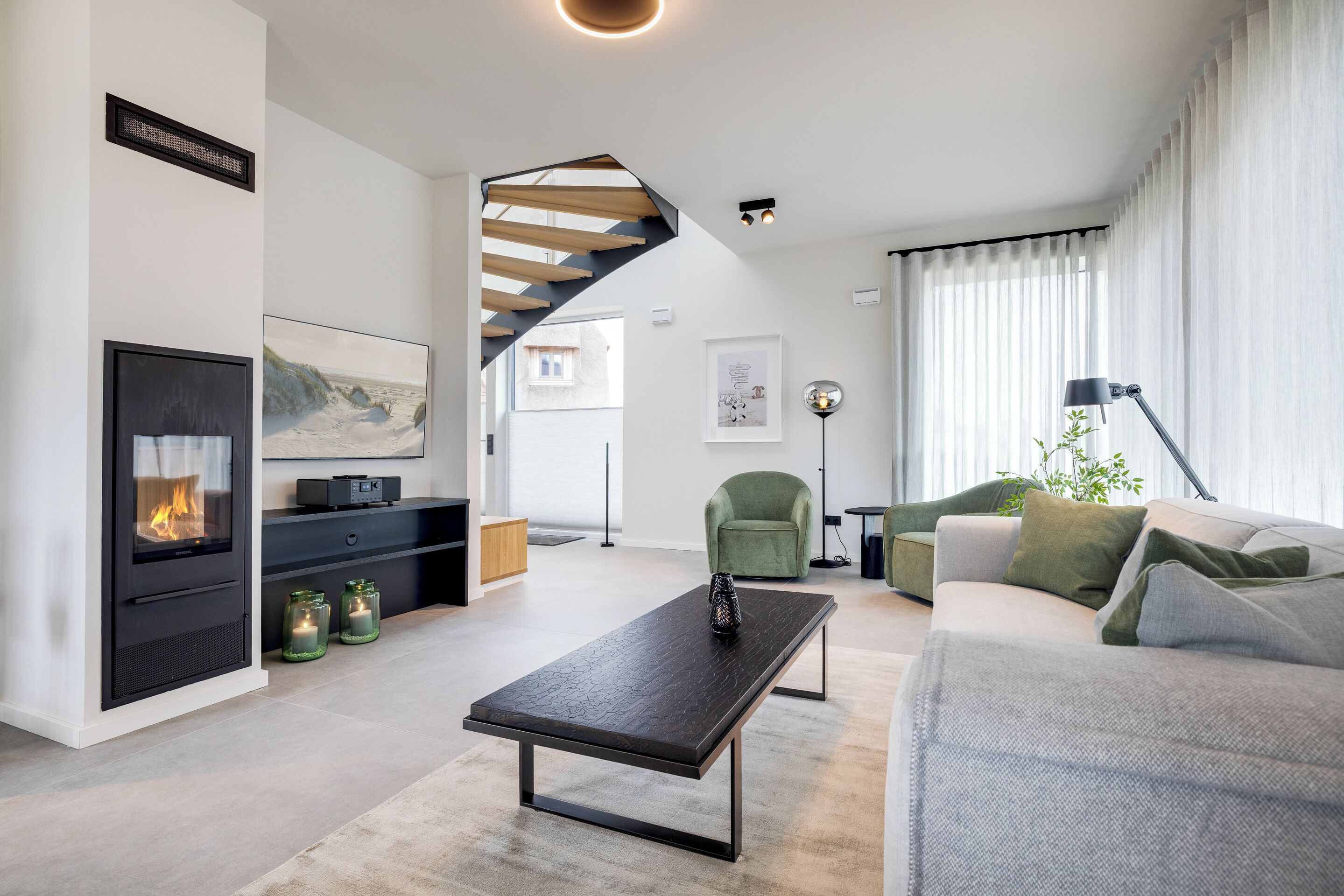 A modern living room with a fireplace, a staircase, a sofa, and a coffee table.