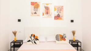 A bedroom with a bed, two nightstands, a wall-mounted TV, and three wall art pieces. - Room 4 a (Trapani)