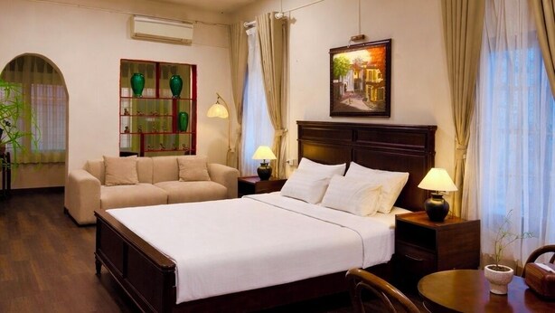 A hotel room with a bed, a sofa, a dining table, and a chair. - Cozy studio Hoan Kiem lake/Opera House/Old quarter (Hà Nội)