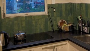 A kitchen with a window, a sink, a dish rack, and a kettle. - Cozy studio Hoan Kiem lake/Opera House/Old quarter (Hà Nội)