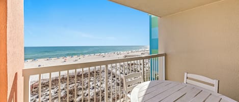 A balcony with a view of a beach and ocean.