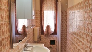 Un baño con lavamanos, espejo y ducha.