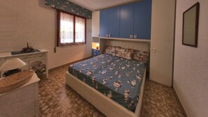 Un dormitorio con una cama, un escritorio y una ventana.