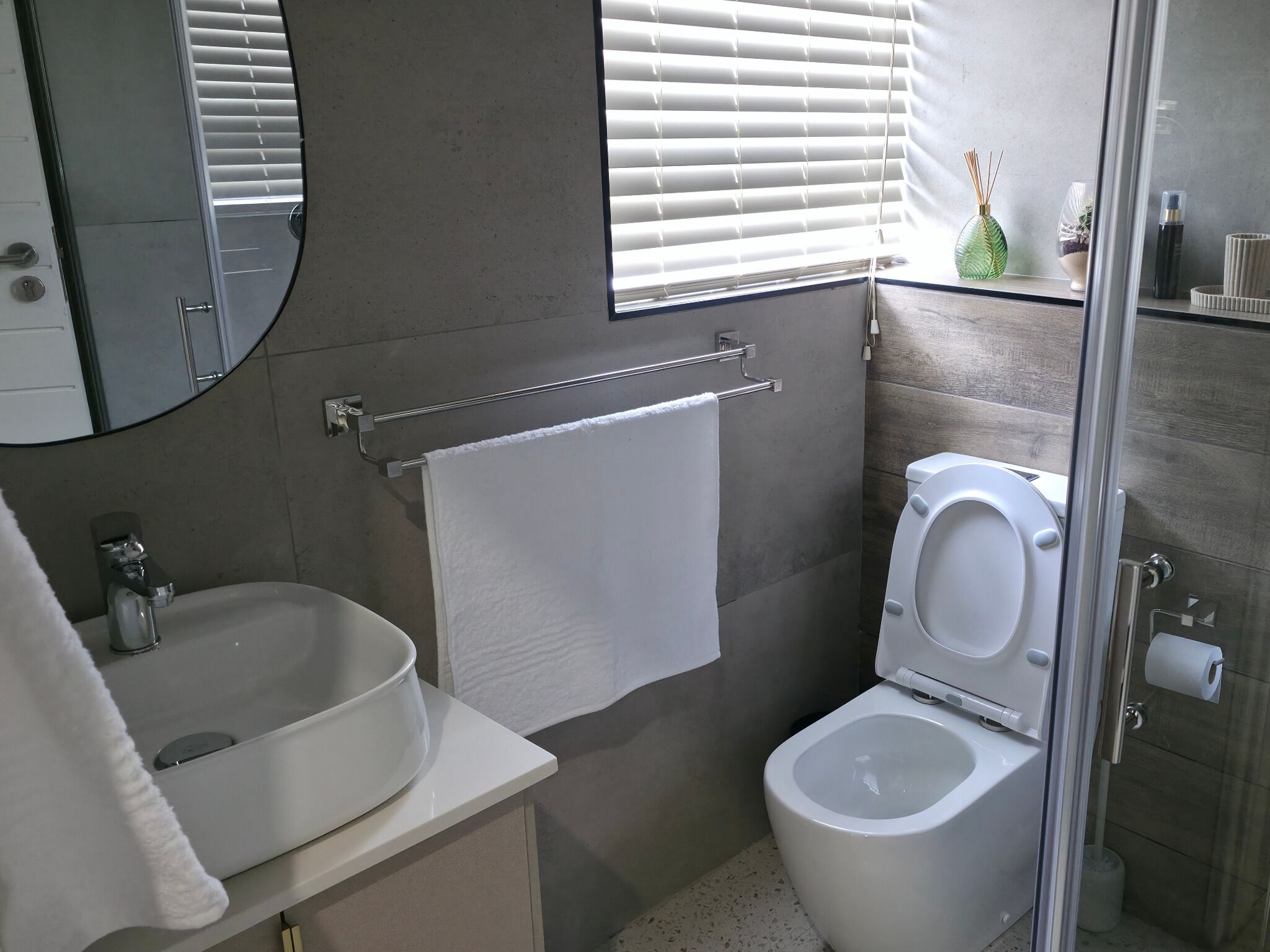 A modern bathroom with a sink, toilet, and shower.