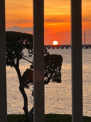 A sunset over water with a bridge and trees in the foreground. - Oceanview 2BR/1.5BA Bungalow 5079: Village at Hawks Cay Villas (Duck Key)