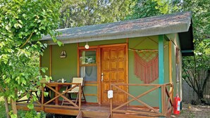 Ein kleines, einstöckiges Holzgebäude mit einer Veranda und einer Tür.