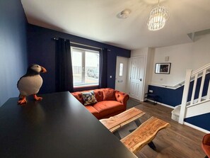 Un salon moderne avec un canapé, une table basse et une table à manger.