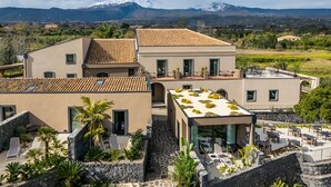 A modern villa with a rooftop terrace, a stone wall, and a view of snow-capped mountains. - Flora Sicula - Cultivating Hospitality (Giarre)