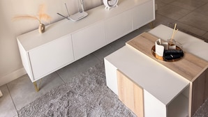 A modern living room with a flat-screen TV mounted on a white cabinet, a marble-patterned wall, a kitchen area with a microwave, and a grey shaggy rug. - Crystal Ace Lagoon & Pool Bliss (Johannesburg)