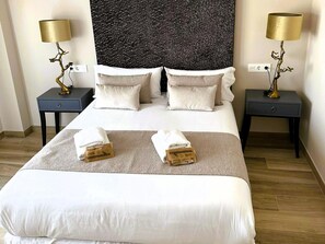 A hotel room with a large bed, two bedside tables, and lamps. - Stunning penthouse with terrace in downtown (Valencia)